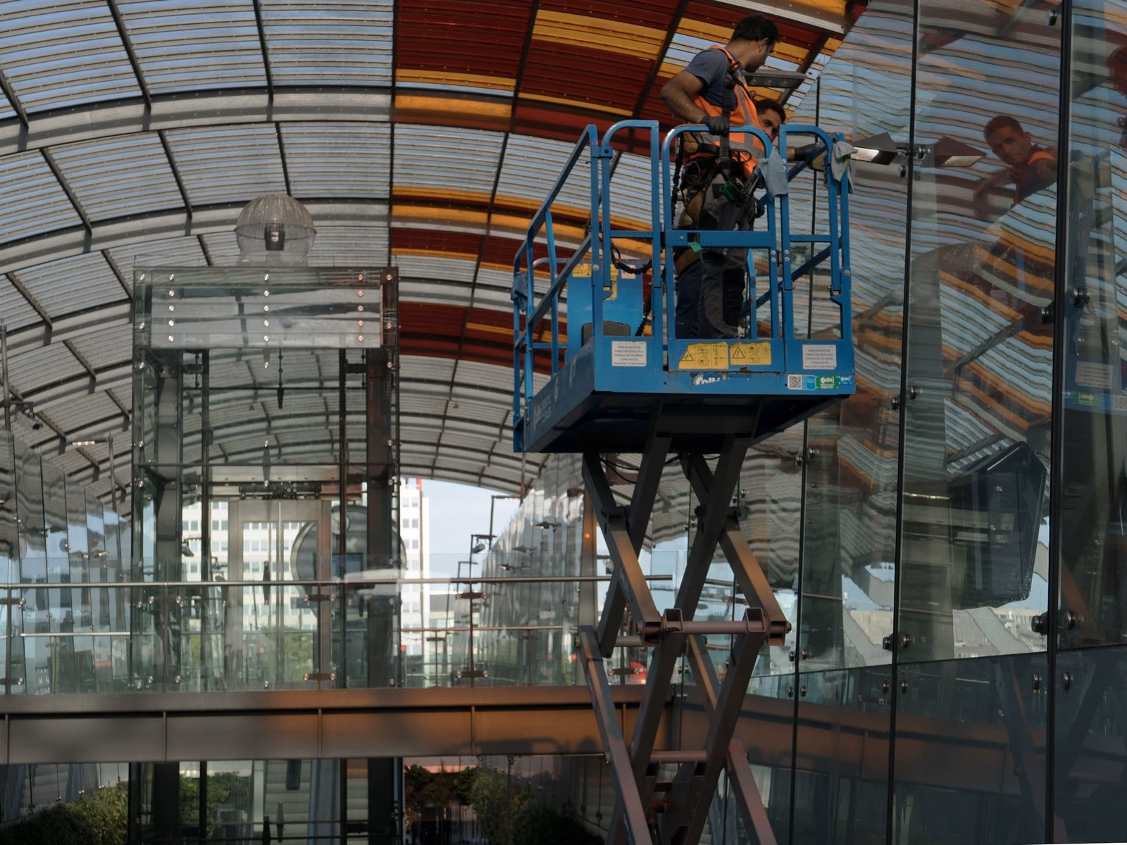 Fönsterputsare rengör en stor glasfasad från skylift